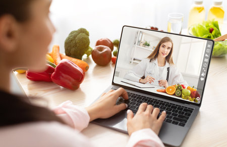 Lady having video call with dietitian, using laptopの写真素材