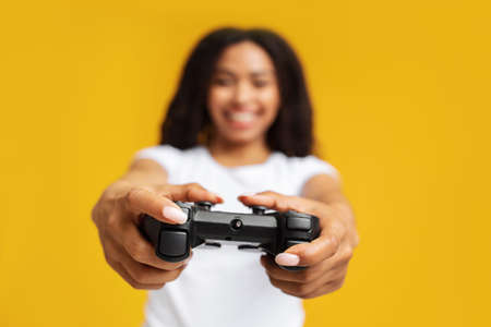 New videogame advertisement concept. Overjoyed african american woman holding game controller,...