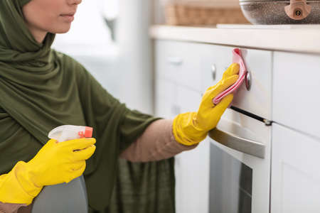 Muslim young woman cleaning dining table at kitchen
