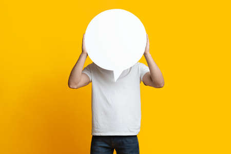 Unrecognizable man hiding behind empty communication bubble