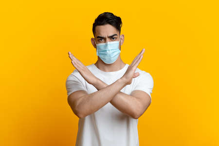 Arab guy with face mask showing stop or no gestureの写真素材