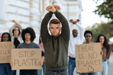 Caucasian guy leader leading international group of protestorsの写真素材