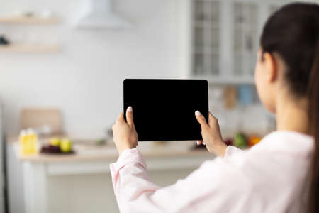 Lady using digital tablet with blank empty screen, mock upの写真素材
