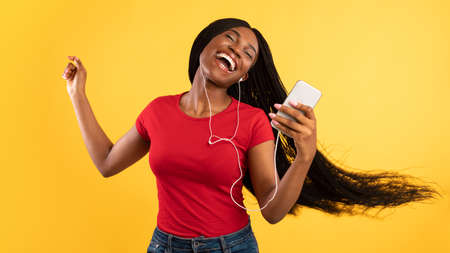 Black Lady Listening Music On Smartphone Wearing Earphones, Yellow Background