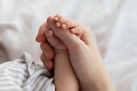 Mothers Protection. Closeup Of Unrecognizable Mom Holding Tiny Hand Of Newborn Baby