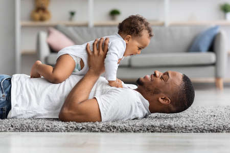 Fathers Love. Happy Young Black Dad Bonding With Newborn Baby At Homeの写真素材