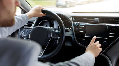 Man driving own new car sits on seat hand, holds steering wheel in modern auto