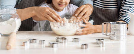Cropped of father, mother and daughter baking together