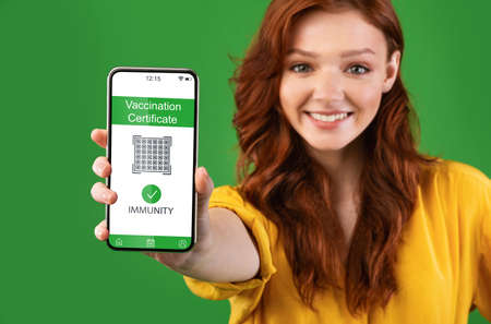 Young woman showing smartphone with digital health passport