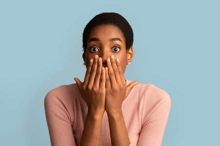 OMG. Portrait Of Shocked African American Lady Covering Mouth With Hands