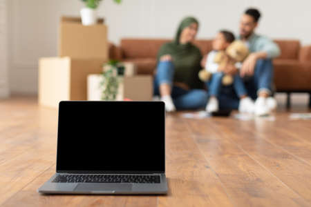 Happy muslim family doing repair in new house using latopの写真素材