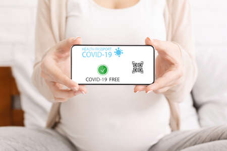 Pregnant lady using smartphone with digital health passportの写真素材