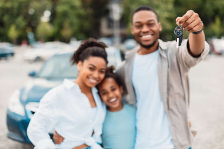 Joyful African American Family Showing New Car Key Standing Outdoorsの写真素材
