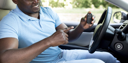 Unrecognizable black man showing car key, panorama