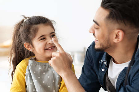 Baking Fun. Little Girl And Her Arab Dad Fooling Together In Kitchen