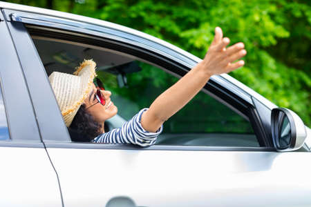 Joyful young lady relaxing while going car trip