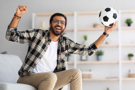 Emotional arab guy football fan watching game on TVの写真素材
