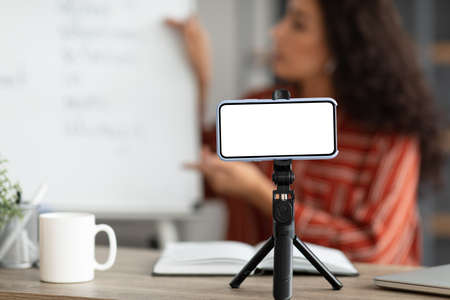 Teacher recording video, selective focus on blank gadget screenの写真素材