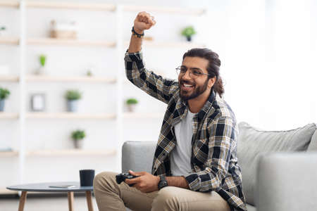 Emotional middle-eastern man playing video games at home