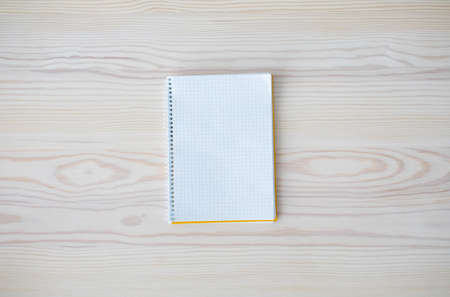 Empty white spiral notepad as mockup for your design on wooden table background, top view, free...