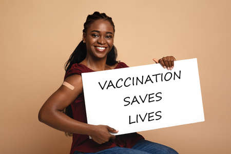 Pretty black woman with Vaccination Saves Lives placardの写真素材