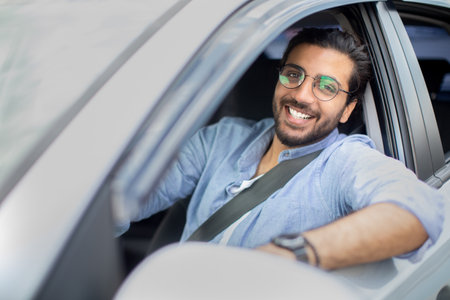 Handsome middle-eastern man driving car, shot from outsideの写真素材