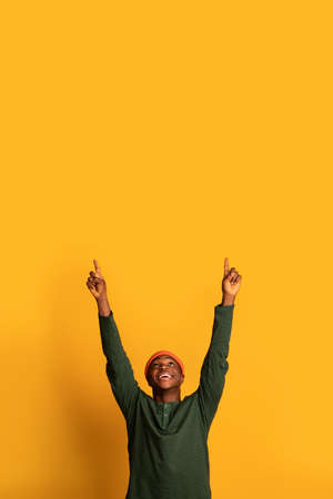 Check This. Cheerful African Guy Pointing Up At Copy Space Above Head