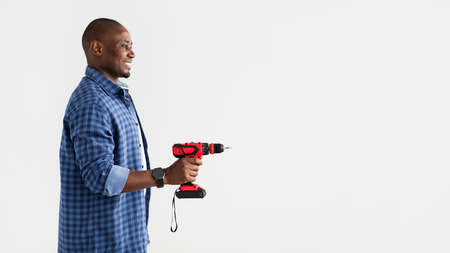 Tool for drilling, fixing and professional builder. African american man holding electric drill over...