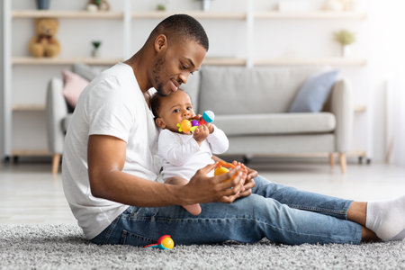 Paternity Time. Loving Young African-American Father Playing With Infant Baby At Home