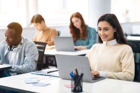 Group of international people using laptops in classroom