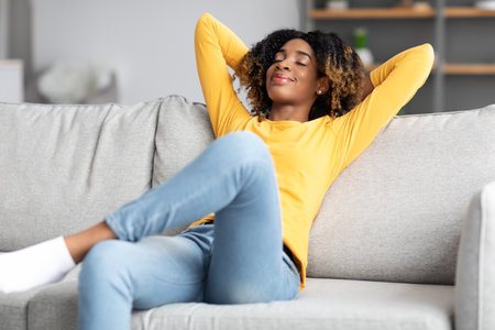 Life Is Good. Relaxed African American Lady Resting On Sofa At Homeの写真素材