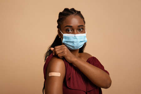 Portrait of black woman with adhesive band wearing face maskの写真素材