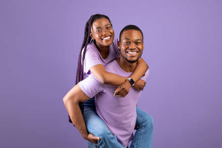 African American man giving piggyback ride for his woman