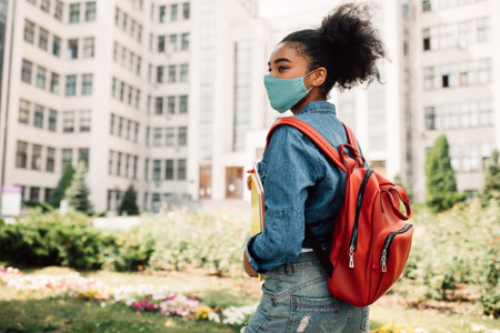 Black Student Girl Wearing Face Mask Posing With Backpack Outsideの写真素材
