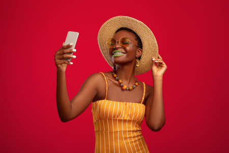 Hot black lady in summer outfit making vacation selfie