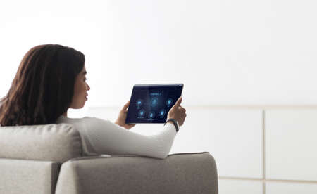 African woman using smart house application on digital padの写真素材