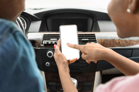Black man and woman using mobile phone in car, mockup
