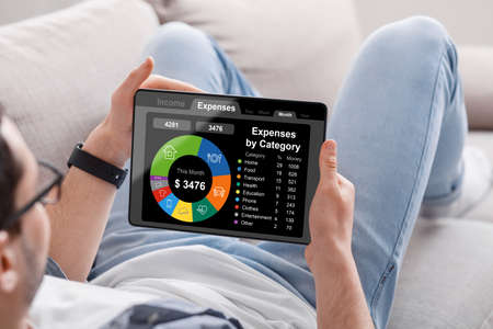 Man using digital tablet with financial application on screen