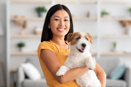 Smiling asian woman posing with her beautiful jack russel puppyの写真素材