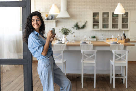 Beautiful young lady relaxing with cup of coffee at home, copy spaceの写真素材