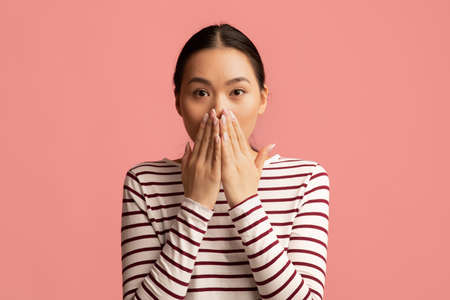 Shocked Asian Lady Covering Mouth With Hands And Looking At Camera With Afraid