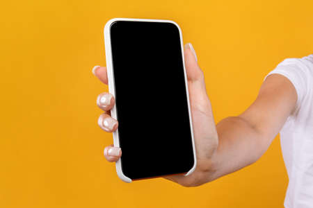 Woman showing black empty smartphone screen close to camera