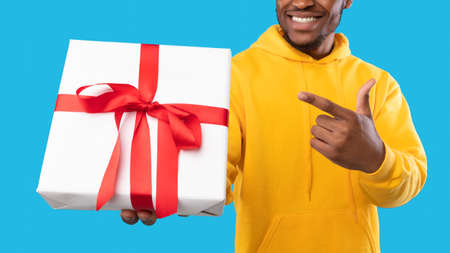 Unrecognizable African Guy Holding Wrapped Present Box, Blue Background, Panorama
