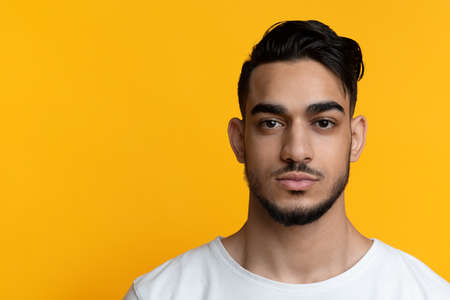 Attractive bearded arabic guy posing on yellowの写真素材