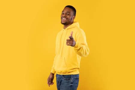 Smiling Black Man Pointing Finger At Camera Over Yellow Backgroundの写真素材
