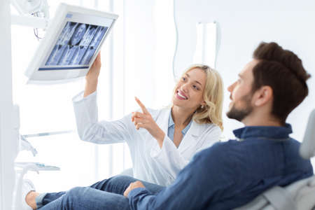 Doctor having conversation with male patient, poitning at LED display