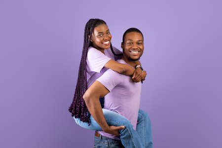 African American man giving piggyback ride for his ladyの写真素材