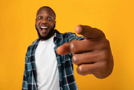 Excited African Man Pointing At Camera, Yellow Background