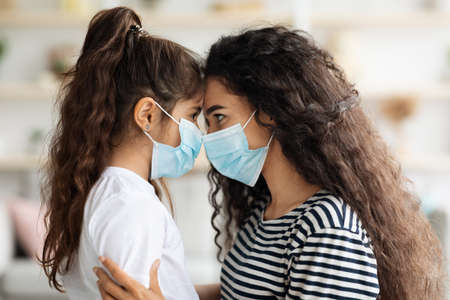 Side view of woman and kid wearing face masks, closeupの写真素材