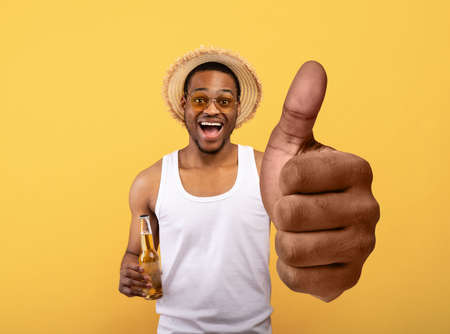 Funky black guy in summer clothes showing big thumb upの写真素材